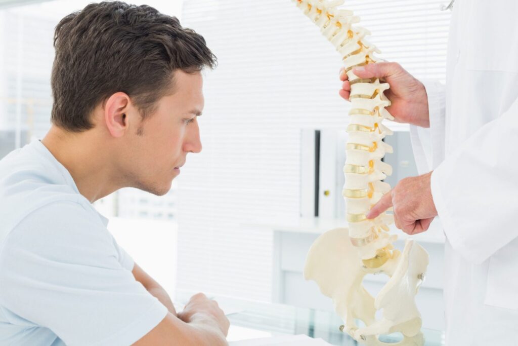 fysioterapeut viser patient hvor problemer sidder i rygsøjlen
